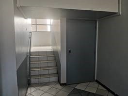 Photo d'un intérieur de bâtiment avec une porte et un escalier