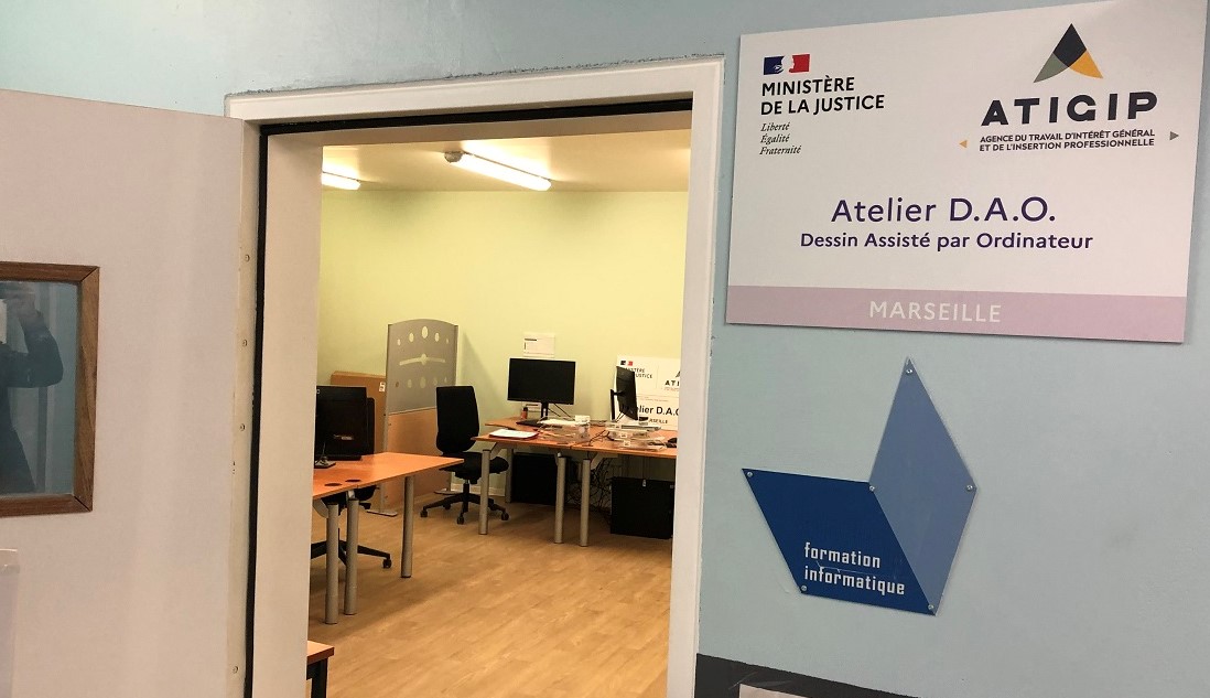 Photo d'une salle avec à l'entrée un écriteau "Atelier D.A.O - Dessin Assisté par Ordinateur  - Marseille"