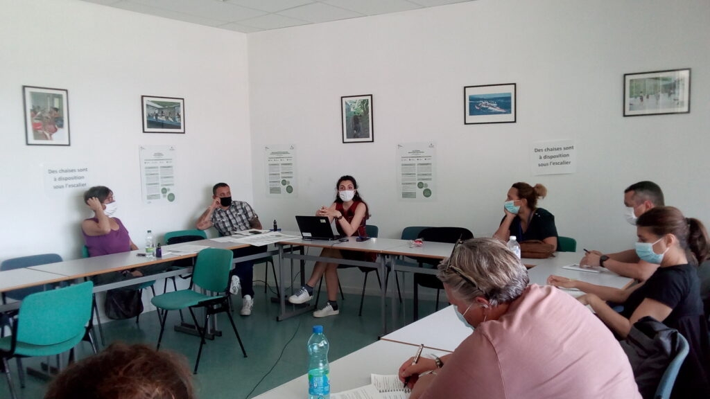 Plusieurs personnes masquées dans une salle assises autour d'une table durant une formation de l'Atigip à l'ÉNAP (juin 2021)