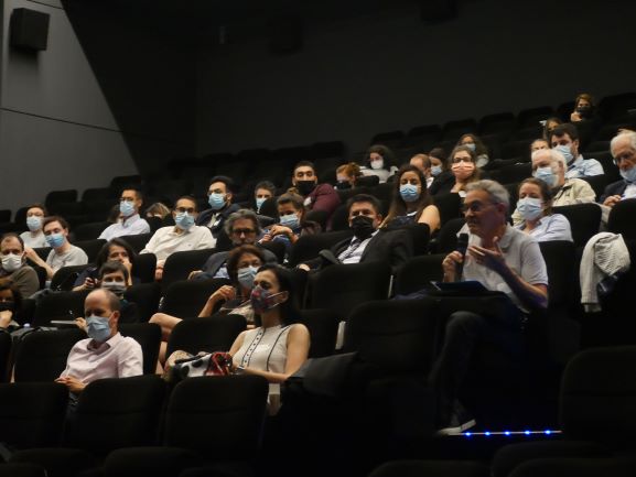 Une personne parle dans un micro parmi une audience à une conférence