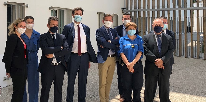 Un groupe de personnes debout masquées en costume dans l'enceinte d'une prison